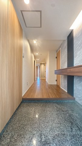 【玄関】 | グランドメゾン長丘 | 玄関は光沢のある床材で、汚れもとても落としやすい。こういうちょっとした気遣いが長く住むと効いてくるんです。