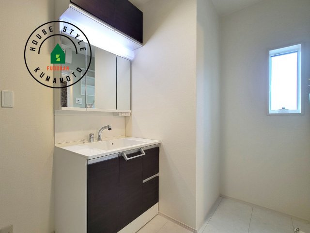 熊本市東区京塚本町第2-1棟（1号棟）の内観：施工例|毎日使うものだから清潔な空間を保ちたい水回り。洗面にはそんな願いを解消させてくれる収納アイデアが満載です。三面鏡の裏側にはキャビネットが現れ小物から背の高い物まで収納できます。