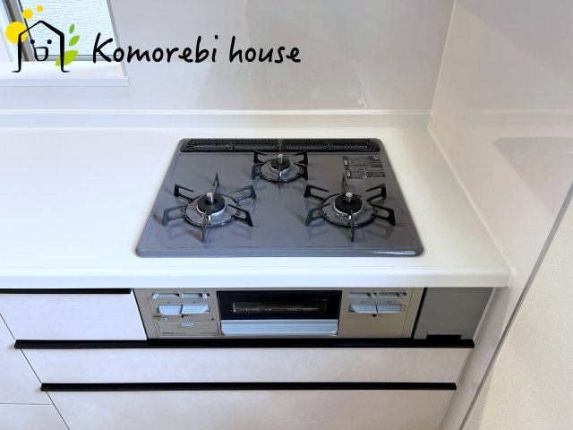 桶川市上日出谷1269番　新築一戸建て　ハートフルタウン　Aのキッチン|同時調理が叶う3口コンロと便利なグリル付き。忙しい朝のお弁当作りも、夕食の複数メニューもスムーズにこなせる頼れる設備です。