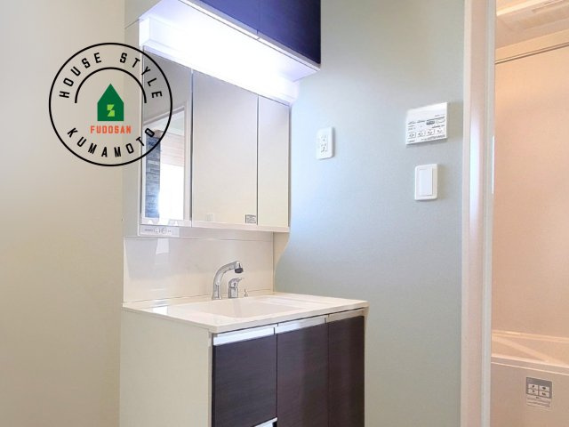 熊本市北区鶴羽田1丁目第1-4棟（2号棟）の内観：施工例|毎日使うものだから清潔な空間を保ちたい水回り。洗面にはそんな願いを解消させてくれる収納アイデアが満載です。三面鏡の裏側にはキャビネットが現れ小物から背の高い物まで収納できます。