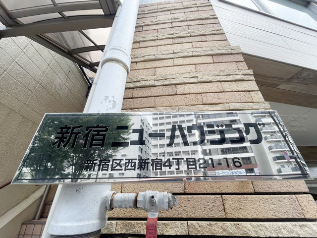 【現況写真】 | 新宿ニューハウジング | エントランスに掲げられた、マンション名を示す館銘板。さほど激しく主張はしませんが、しっかりと掲示されています。～即日のご見学可能～　お問合せはお気軽にどうぞ。