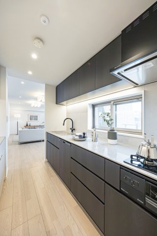 神楽坂パークハウスのキッチン|使いやすさとデザイン性を兼ね備えた田中工藝製のシステムキッチンです。木目調の面材が上質なお部屋に調和しています