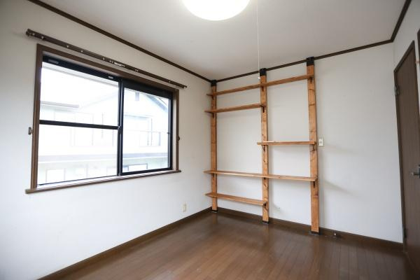 高江中央2丁目中古の洋室|大きな窓からたっぷりと自然光が入ります。壁面の収納棚が便利で落ち着いた色合いの床が印象的です。シンプルな洋室でレイアウトが楽しめます。
