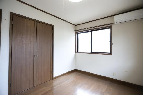 高江中央2丁目中古の洋室|大きな窓からたっぷりと自然光が入ります。壁面の収納棚が便利です。落ち着いた色合いの床が印象的です。シンプルな洋室でレイアウトが楽しめます。清潔感のある空間です。