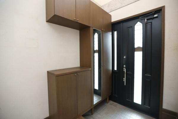 高江中央2丁目中古の玄関|玄関にはたっぷり収納できるシューズボックスが設置されています。鏡付きでお出かけ前のチェックにも便利です。ドアは採光窓付きで明るさを確保しています。シンプルなデザインが特徴的です。