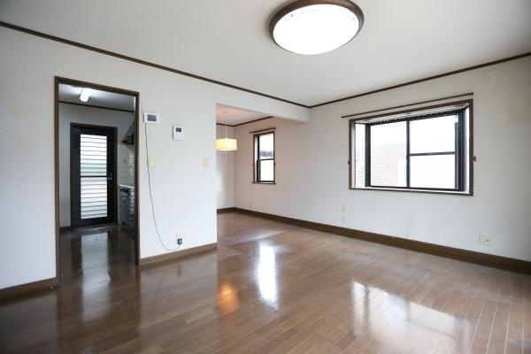 高江中央2丁目中古の居間・リビング|リビングは大きな窓から光がしっかり入り開放的な雰囲気です。床は落ち着いた色合いで家具の配置がしやすそうです。壁面には便利な室内窓もついており空間に広がりを感じます。