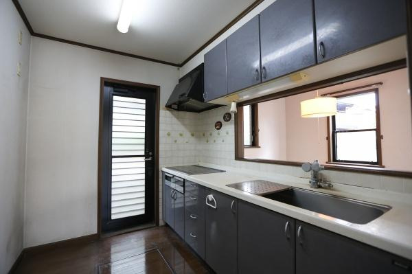 高江中央2丁目中古のキッチン|キッチンに勝手口があり便利です。収納スペースが豊富で効率的な家事動線をサポートします。扉付きの収納が多くすっきりとした印象です。