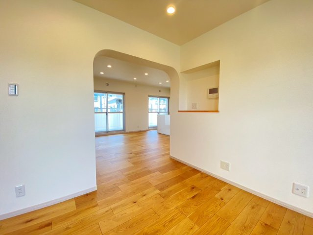 【価格改定】長岡天神ハイツ10棟の居間・リビング|ダイニングスペースからリビングへの動線にはアーチ状の天井で大変お洒落な造りとなっております！