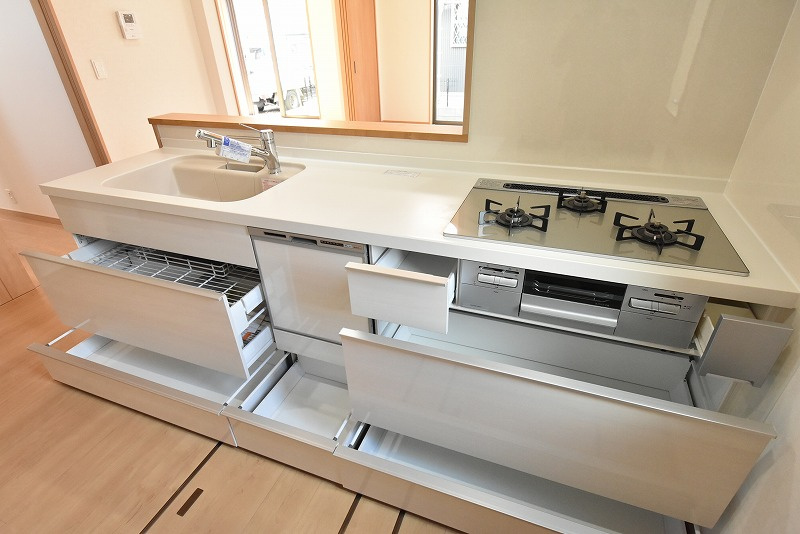 鴻巣市本町３丁目　新築住宅全２棟のキッチン|シンク下の引き出しはアシストポケット・シェルフ付き、足元引き出し収納付きなど収納力も充実なキッチン。