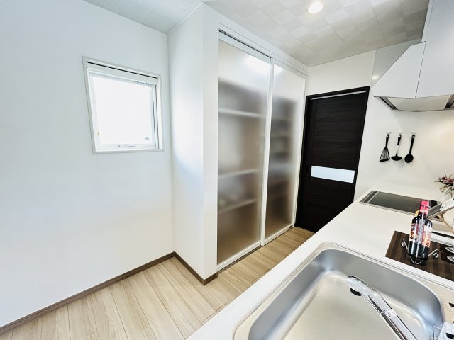 新築　渋川市行幸田　平屋一戸建てのキッチン|現地写真　背面収納は、すりガラスの引き戸で目隠しされています。大容量の収納でスッキリできます。