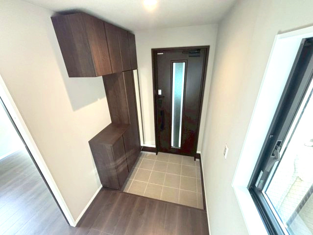 下伊敷１丁目　新築戸建ての玄関|豊富な下駄箱収納です。姿見付き。家族分の靴もたっぷり収納できます。