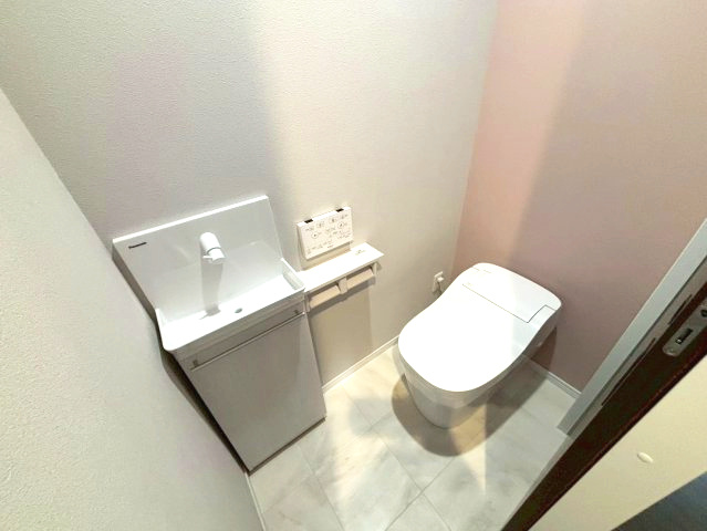 下伊敷１丁目　新築戸建てのトイレ|1階の温水洗浄便座トイレです。手洗い場付きの収納もついており掃除道具を収納することができます。