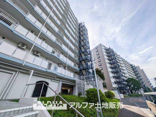 西武拝島ハイツ1号棟の外観|緑の植え込みが優しく迎えてくれるアプローチ。明るく整った外観が街並みに心地よく溶け込んでいます。

