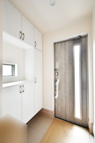 桶川上日出谷1269番全3棟　A号棟の玄関|白を基調とした玄関には窓もありますので、玄関も外からの光が差し込みます。また間のスペースには鍵を置くスペースにする事で、外出前に鍵を探すなど慌ただしさが軽減されるのでおすすめです。