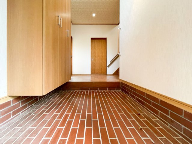 東灘区住吉台中古戸建の玄関|ウッド調の建具が魅力的な温かみのある玄関。吹き抜けの窓からは心地の良い光が入り、葉っぱの影がゆらゆらと時間の流れをゆったりと感じられる空間です。