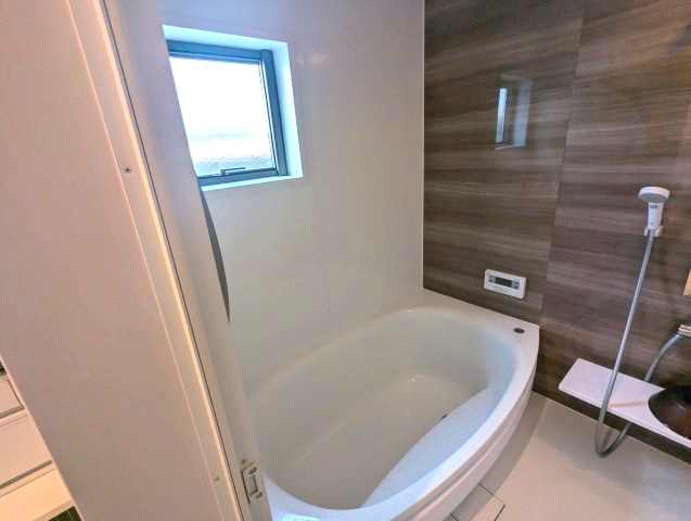売中古戸建　駿東郡長泉町下長窪の浴室|窓があるので明るい室内です。備え付けの台があるのでシャンプーを置いたり出来て便利です。