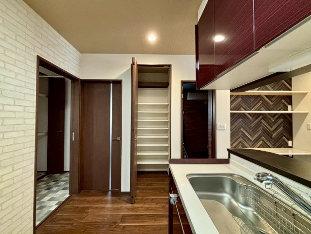 野田市柳沢　中古戸建　令和3年築の居間・リビング|リビングにはスペースを活用したカウンターと棚があります！カウンターは勉強やデスクワークに活躍します！上には2段の棚があり、収納スペースとしても活用できます！