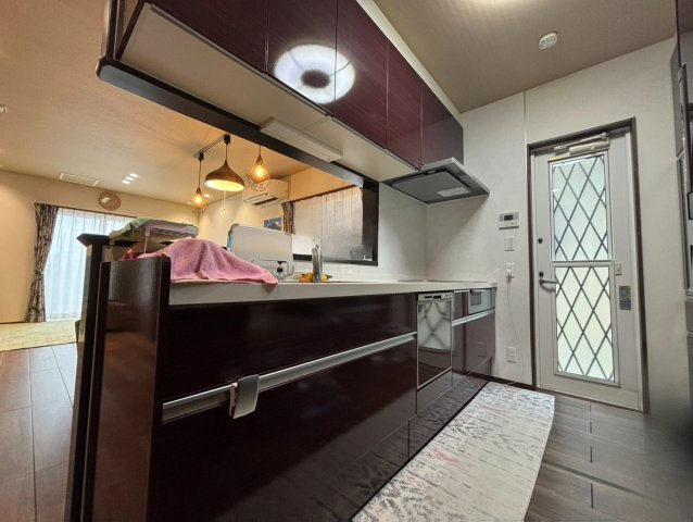 野田市柳沢　中古戸建　令和3年築のキッチン|赤を基調としたオシャレな対面式キッチンです！勝手口もあるので、ゴミをリビングまど通らずに最短で外に持っていくことが可能です！