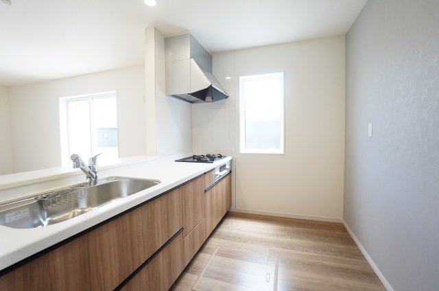 リーブルガーデン美浜町奥田西卯起　3号棟のキッチン|グレーのアクセントクロスが落ち着いた雰囲気のキッチンは、使いやすく対面式カウンター付きで
家族の様子がわかります