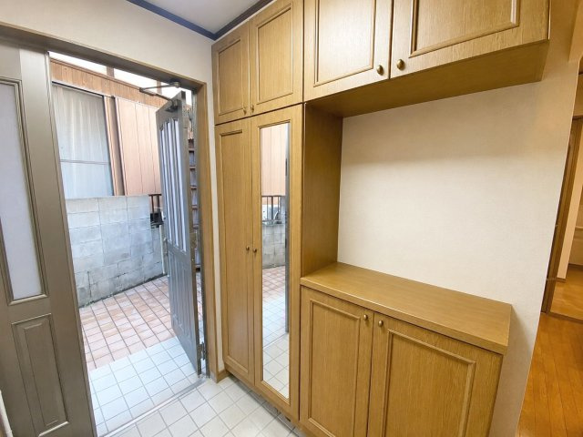 粕屋町長者原西１丁目 店舗付き住宅の玄関|コの字型シューズボックスでご家族の靴をスッキリ整理できます！
※AI加工により荷物を消去しています（現況優先）