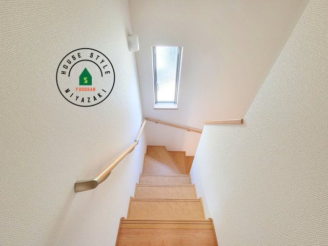 宮崎市本郷南方第1-1棟（1号棟）の内装|＜手すり付階段＞手すりがないと階段の昇り降りで危険なことはもちろん、壁に手をつきながら歩くことで壁紙が汚れやすくなります。すべての方に快適に昇り降りしていただくため、手すりを設置しました。