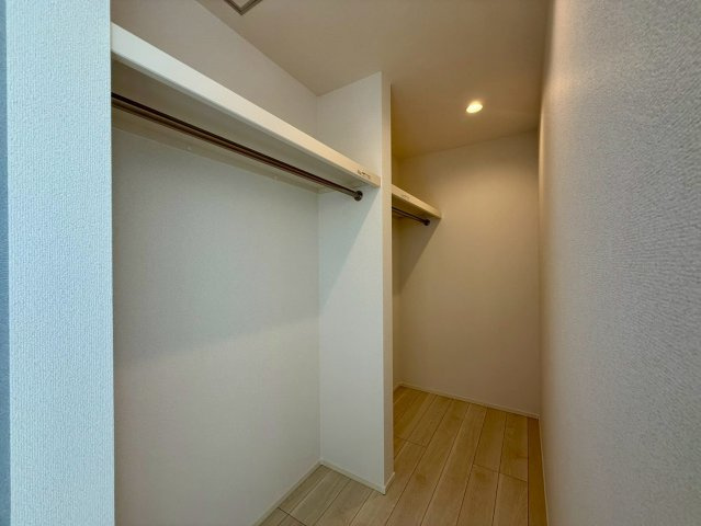 香美市土佐山田町宝町2期5棟 2号棟の収納|主寝室には広々としたウォークインクローゼットを設置。
ハンガーパイプが両側にあり、衣類を掛けたまま整理できる設計です。