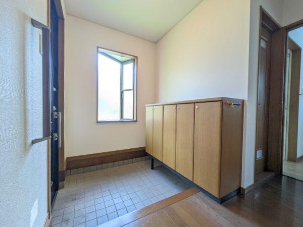 けやき台二丁目　中古の玄関|明るい窓から自然光が差し込む玄関です。広めのスペースでゆったりとした印象があります。収納も充実しており靴や小物の整理に便利です。木目調のデザインが空間に温かみを感じさせます。