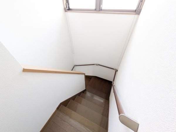 けやき台二丁目　中古の内装|手すりが設置された階段で昇降の際にも安心感があります。木目調の落ち着いた色合いが特徴的です。上部には窓があり階段スペースに自然光が差し込みます。すっきりとした内装で清潔感も感じられます。