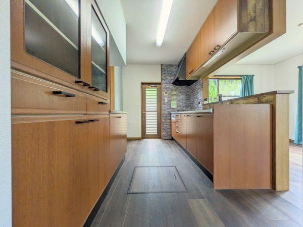けやき台二丁目　中古のキッチン|木目調のデザインが空間に温かみを与えています。収納が豊富で片付けもスムーズです。窓からの自然光が明るさを演出しています。動線がシンプルで使いやすさが感じられます。