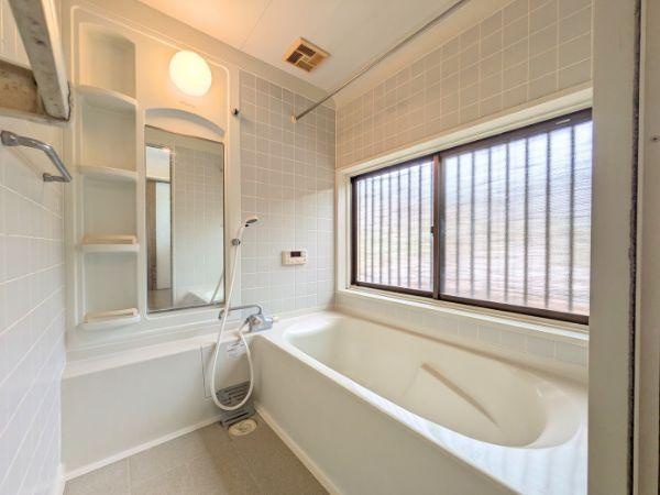 けやき台二丁目　中古の浴室|窓が大きく採光が取れるバス空間です。壁面には収納棚があり小物の整理に便利です。浴槽と洗い場がしっかり分かれており使いやすさが感じられます。白を基調とした内装で清潔感があります。
