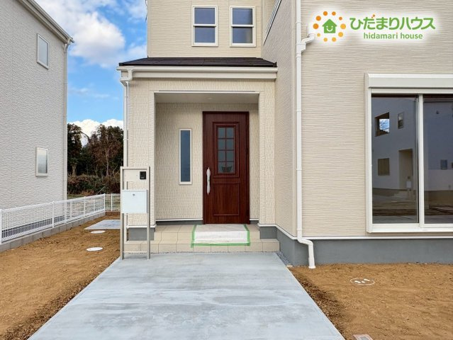 寄居町露梨子　新築一戸建て　リーブルガーデン　02の玄関|屋根のついたアプローチで、雨の日でも傘を落ち着いてさせる玄関です。明るい色合いの壁にシックなドアが映えるデザインで、帰ってきた時にほっと落ち着けるような佇まいをみせています(^^)