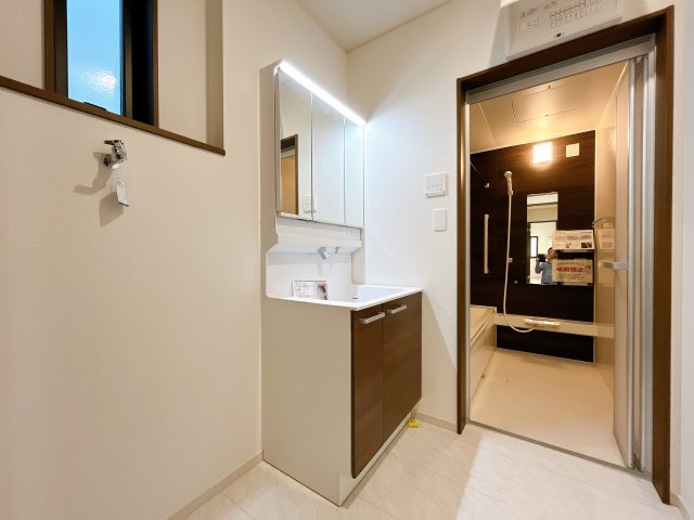 熊谷市上之 　新築戸建　全２棟の独立洗面台|ゆとりの洗面スペースで朝の身支度も快適スムーズに。３面鏡で髪のセットやお化粧もストレスなくこなせ、朝から気分良く通勤通学に向かえそうですね！鏡の裏にはたっぷりと収納スペースを標準装備