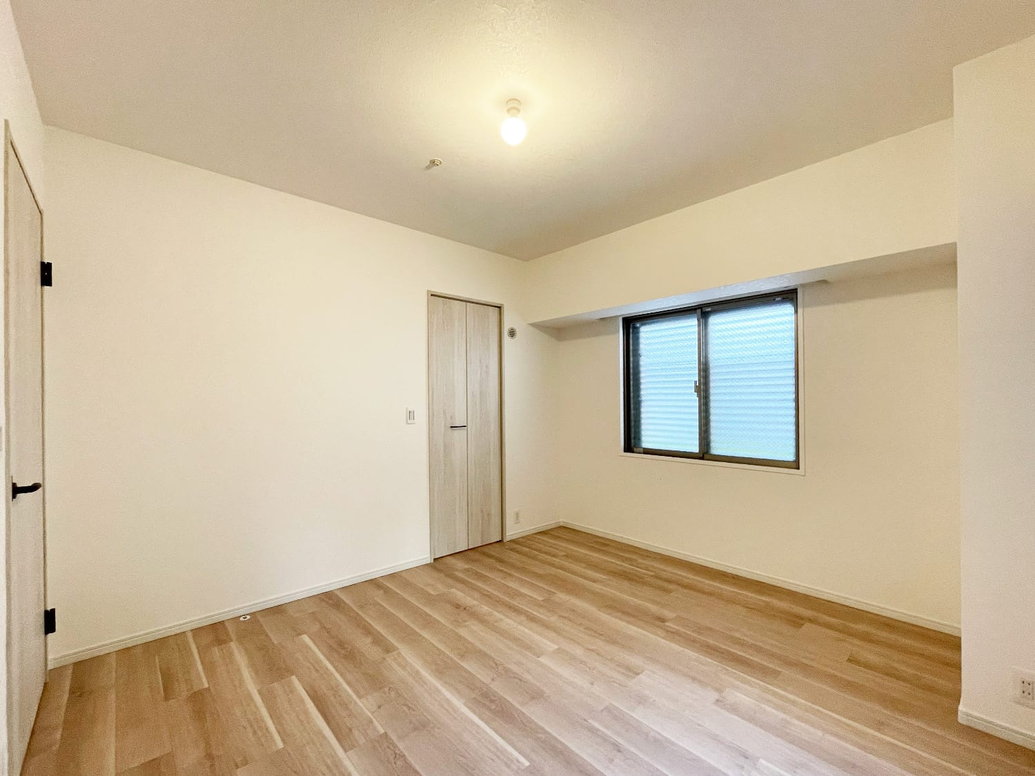 アルス西宮ルシーディアの洋室|約8帖の洋室は北・西の2面採光で、居室の中では一番広いお部屋です。北側の窓からは共用部の植栽を望むことができます。