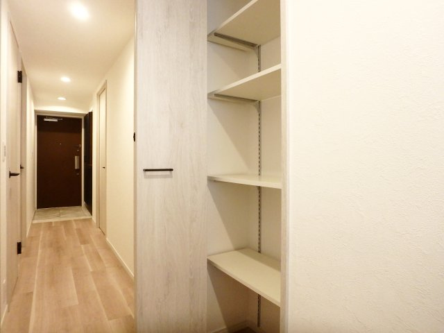 アルス西宮ルシーディアの収納|廊下にも収納棚がございます。棚の高さ調整も可能です。ドア等の建具はホワイトオーク柄の落ち着いたカラーを採用しています。