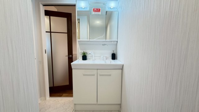 旭コーポB棟の独立洗面台|白を基調とした清潔感のある洗面室◎三面鏡付洗面化粧台で毎朝の準備時間もゆったりと過ごせます。