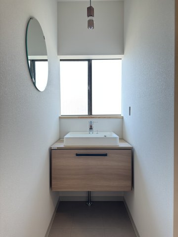 米子市和田町　中古住宅の独立洗面台|丸い鏡がおしゃれな洗面台。窓があり解放感もあります。新品です。