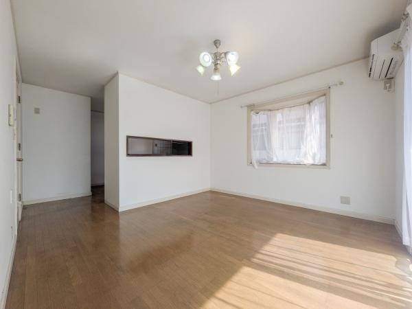 王ノ瀬一丁目　中古の居間・リビング|明るい光が差し込むリビングです。床はお手入れのしやすいフローリング仕様となっています。エアコン設置済みで快適に過ごせます。仕切りの壁に開口があり空間に広がりを感じられます。