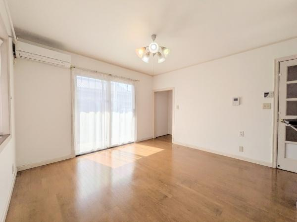 王ノ瀬一丁目　中古の居間・リビング|明るい光が差し込むリビングです。ナチュラルな色合いのフローリングが空間を広く感じさせます。天井照明がスタイリッシュな印象を与えます。エアコンも設置済みです。開放感のある窓が魅力です。