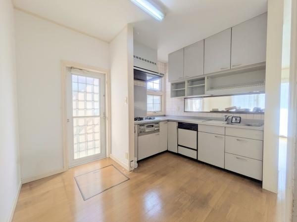 王ノ瀬一丁目　中古のキッチン|明るい日差しが差し込むキッチンです。収納スペースが豊富で調理器具や食器もすっきり整理できます。作業スペースが広く動きやすいレイアウトが魅力です。引き戸付きの勝手口があり通気性にも優れています。