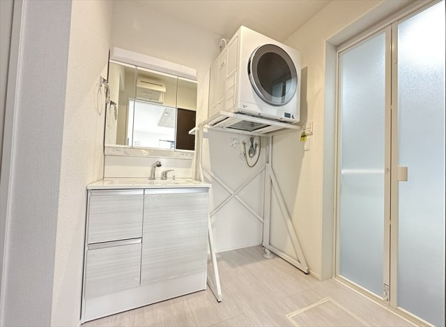 【脱衣所】 | 朝霞市宮戸3丁目　新築一戸建住宅　全2棟　(丸井志木店) | 衣類乾燥機付。三面鏡洗面化粧台は鏡の裏に小物類の収納ができるのでスキンケアグッズもまとめて保管できます。