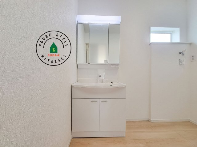 宮崎市島之内第11-3棟　(1号棟)の独立洗面台|毎日使うものだから清潔な空間を保ちたい水回り。洗面にはそんな願いを解消させてくれる収納アイデアが満載です。三面鏡の裏側にはキャビネットが現れ小物から背の高い物まで収納できます。