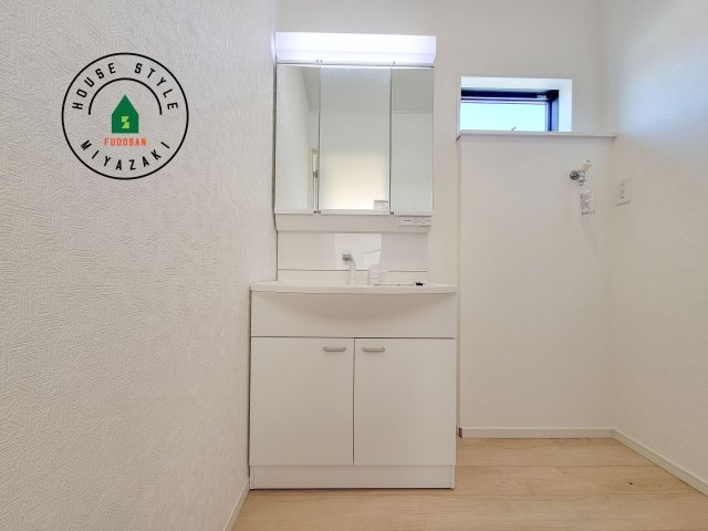 宮崎市島之内第11-3棟　(2号棟)の独立洗面台|毎日使うものだから清潔な空間を保ちたい水回り。洗面にはそんな願いを解消させてくれる収納アイデアが満載です。三面鏡の裏側にはキャビネットが現れ小物から背の高い物まで収納できます。