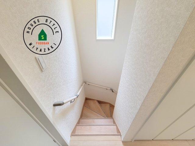 宮崎市島之内第11-3棟　(2号棟)の内装|＜手すり付階段＞手すりがないと階段の昇り降りで危険なことはもちろん、壁に手をつきながら歩くことで壁紙が汚れやすくなります。すべての方に快適に昇り降りしていただくため、手すりを設置しました。