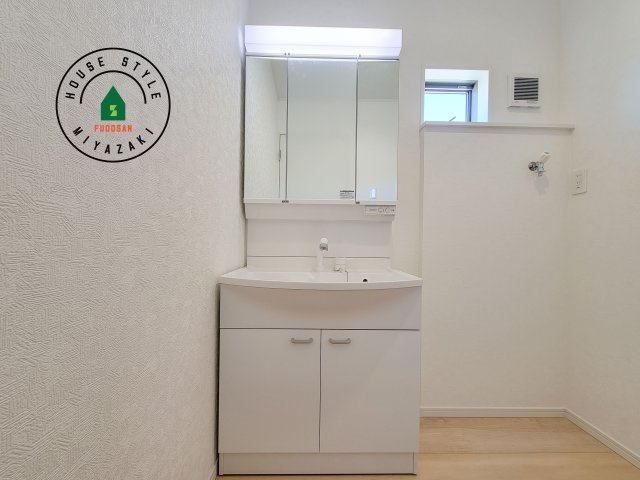 宮崎市島之内第11-3棟　(3号棟)の独立洗面台|毎日使うものだから清潔な空間を保ちたい水回り。洗面にはそんな願いを解消させてくれる収納アイデアが満載です。三面鏡の裏側にはキャビネットが現れ小物から背の高い物まで収納できます。