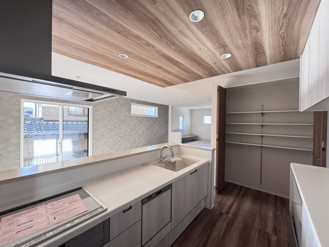 新築戸建　伴東8丁目のキッチン|リビングを見渡せる明るいキッチン！ 奥には便利なパントリーがあり、ストック品の収納に最適です。