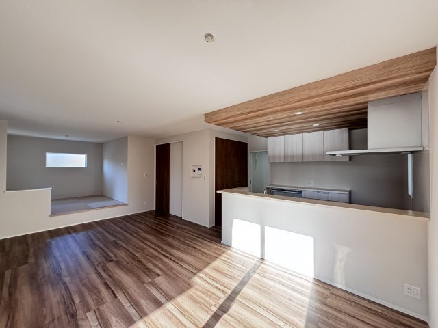 新築戸建　伴東8丁目の居間・リビング|スタイリッシュな対面キッチン！ リビング全体を見渡せ、ご家族を見守りながら料理ができます。