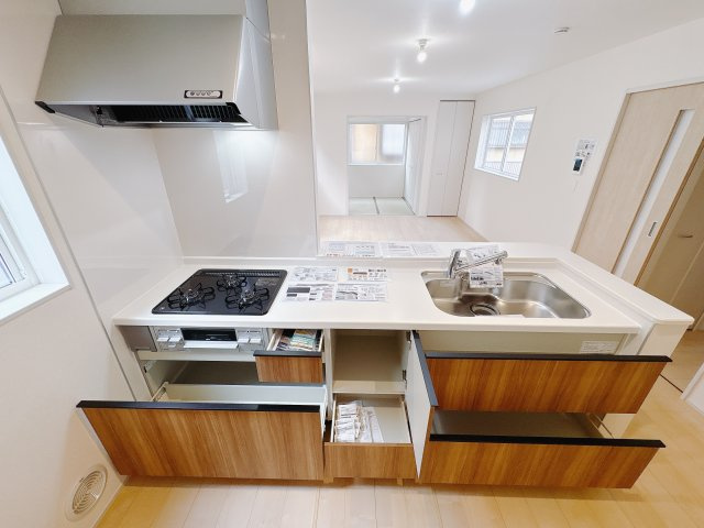 【LiveleGarden】小山市西城南 第5 全2邸のキッチン|〇1号棟　キッチン〇
大きな鍋やフライパンを収納できるスライド収納が完備されています。また、カウンターが広いので作業がしやすく、シンクやコンロなどのお手入れがしやすい仕様です。
