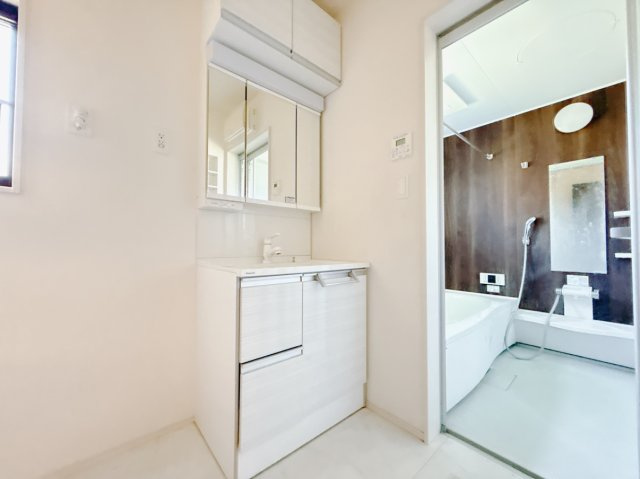 【中古戸建】伊勢崎市八坂町の独立洗面台|■洗面室｜洗濯機を置いてもゆとりある広さの洗面脱衣室です♪三面鏡の洗面化粧台なので身支度もしやすくおしゃれが好きな方にも嬉しい設計です♪窓があるので換気の際も楽ちんです♪