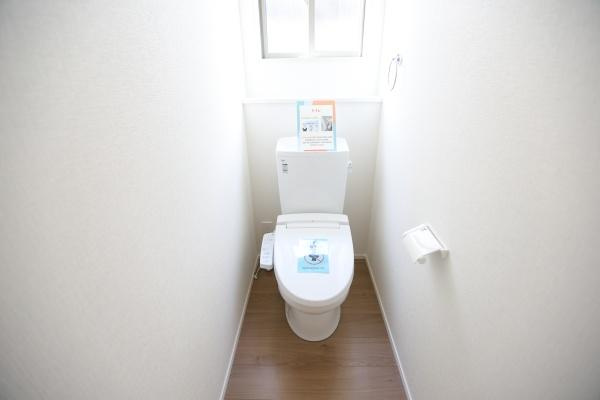 大字森町4期1号棟のトイレ|明るい雰囲気のトイレです。窓があり換気に適しています。清潔感のある空間になっています。床は木目調で落ち着いた印象です。壁紙もシンプルですっきりとしています。
