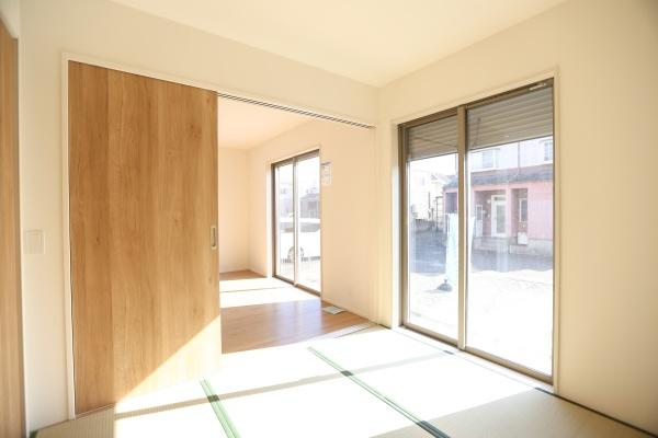大字森町4期1号棟の和室|大きな窓から光が差し込む明るい和室です。木目調の引き戸がやわらかな雰囲気を演出しています。続き間としても使いやすい配置が特徴です。畳の上でくつろげる空間です。開放的な雰囲気のある和室です。